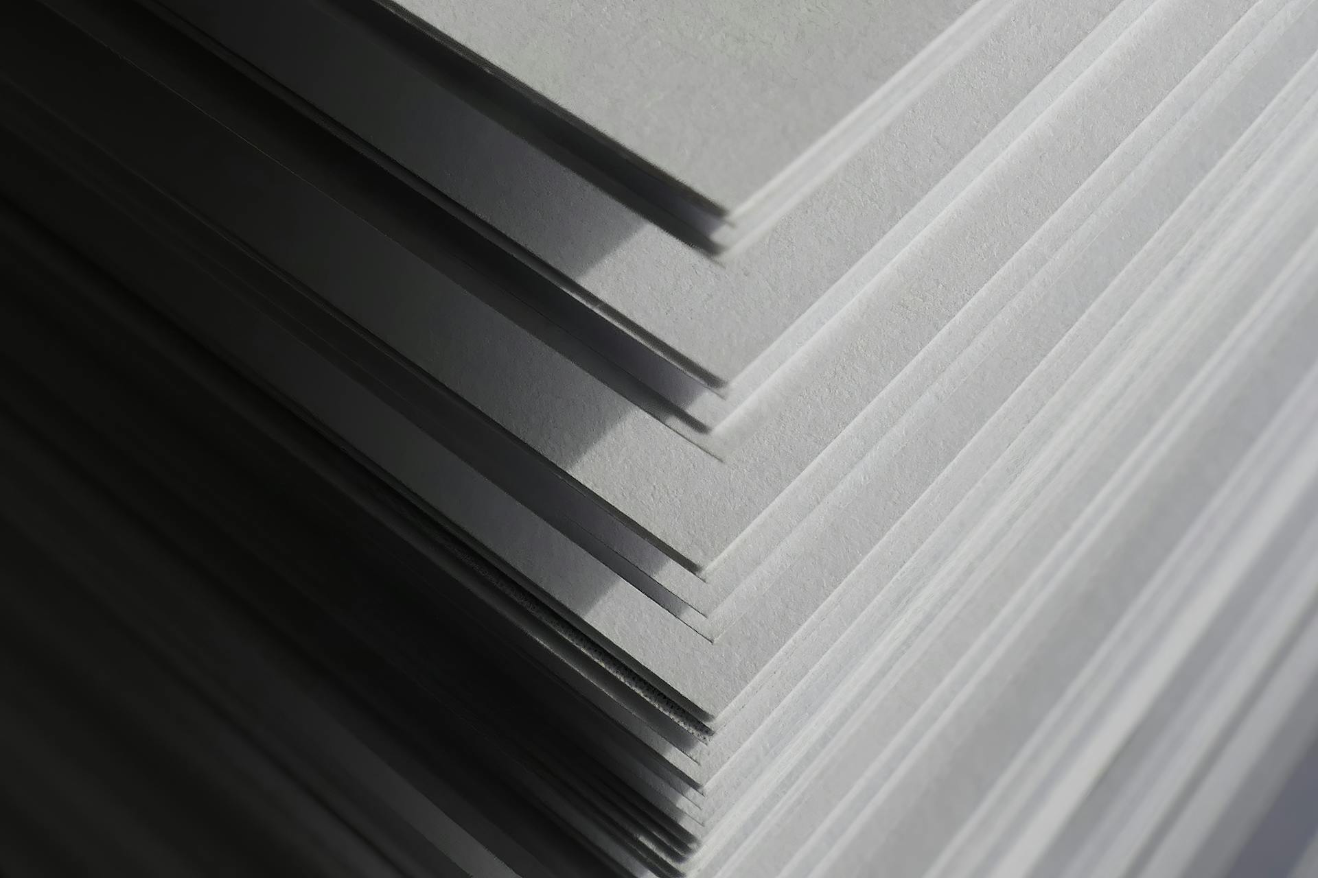 a4 paper price comparison between ream and box quantities shown with stacked office paper sheets