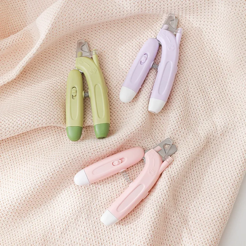 LED pet nail clipper for dogs and cats in pink purple and green.